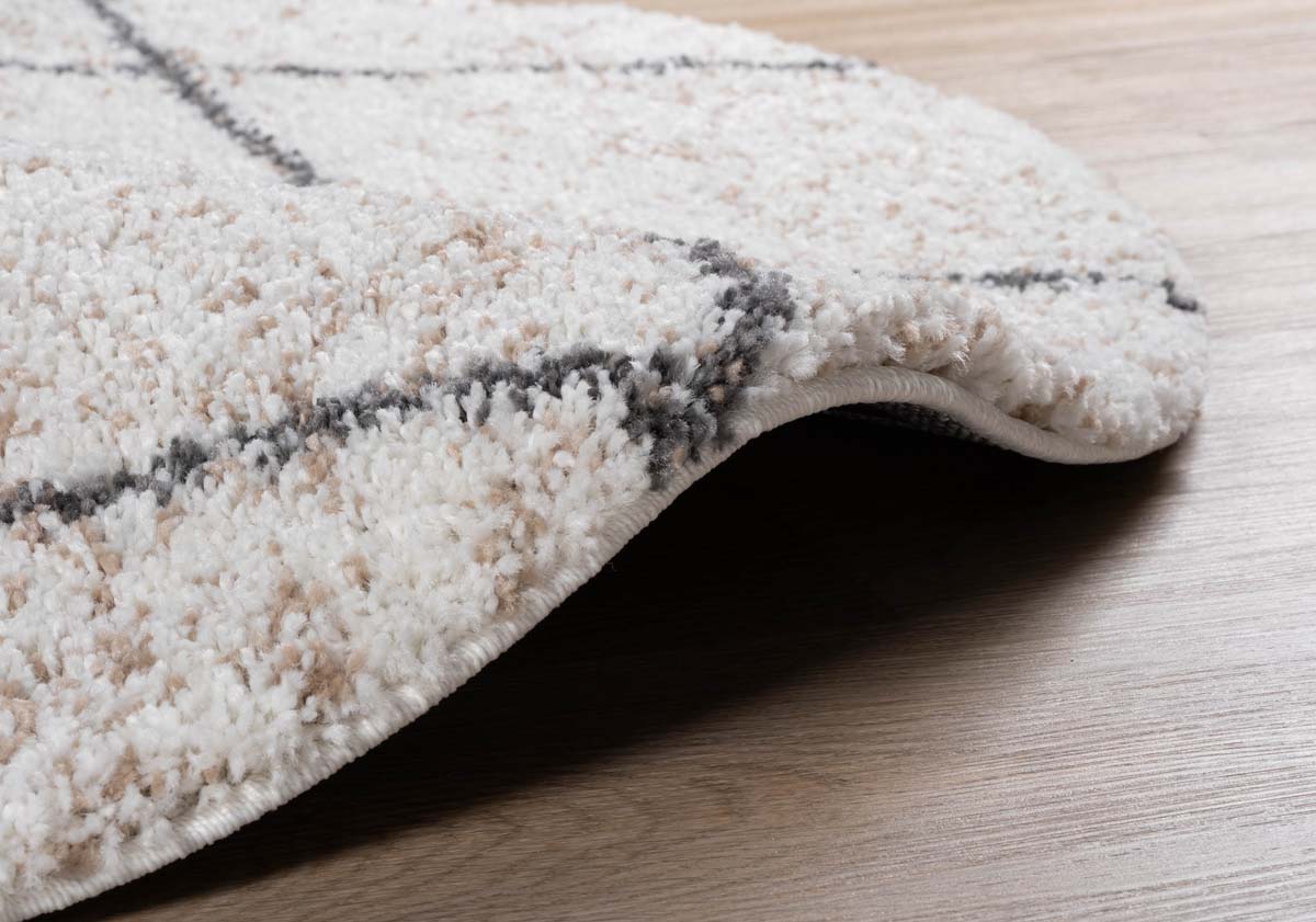 Alfombra redonda a rombos de pelo largo Artisan - Blanco/Gris - close up zijkant Alfombra redonda a rombos de pelo largo Artisan - Blanco/Gris - close up zijkant